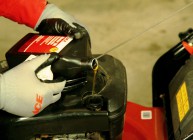 Pouring lawn mower motor oil